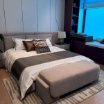 Modern villa bedroom with upholstered bed and custom wall panels
